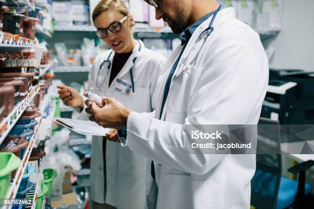 Pharmacists Checking Inventory At Pharmacy Stock Photo - Download Image Now - Hospital, Pharmacist, Pharmacy