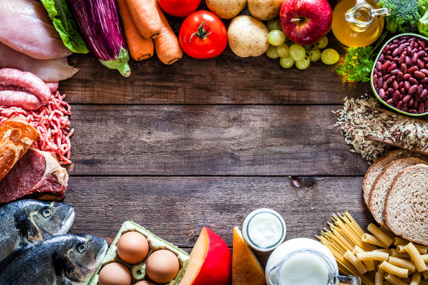 istock Different types of food making a border on rustic wooden table 861162506