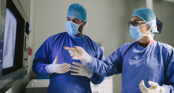 equipo de cirujanos utilizando nueva tecnología en cirugía - performance surgery doctor men fotografías e imágenes de stock