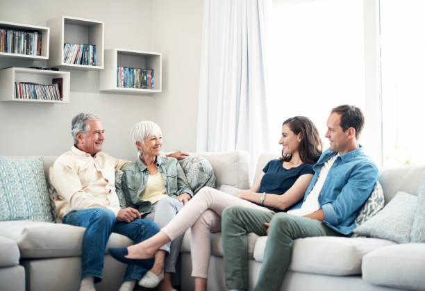 We chat for ages when we get together Shot of a young couple and their elderly parent spending some time together at home father in law stock pictures, royalty-free photos & images