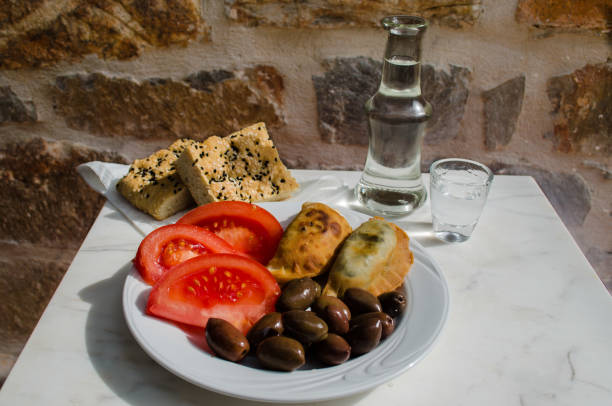 delicious mezes for fasting period and lent including small vegetable pies olives and tomatoes. Ideal for accompanying raki and tsipouro. stock photo