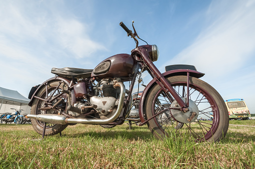 Dunsfold, UK - August 26, 2017: Wide-angle closeup of a vintage British Triumph motorcycle at a gathering of classic and modern vehicles in Dunsfold, UK