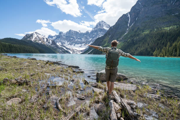 istock Young man balances on a tree log above the lake 861166118