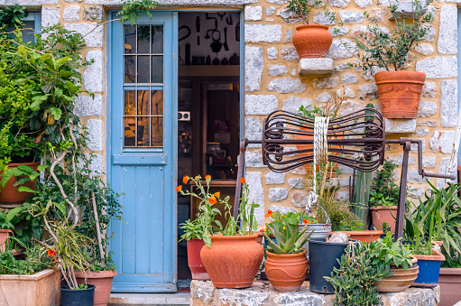 The outside of a french window with shutters and plant pots on the windowsill in Castelferrus, France.