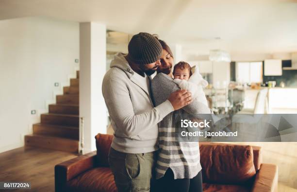 Young Father And Mother Holding Their Baby Boy Stock Photo - Download Image Now - Newborn, Young Family, Two Parents