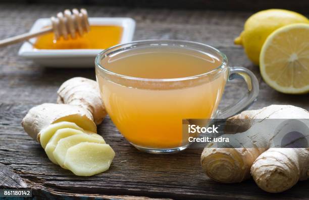 Ginger Homemade Tea Infusion On Wooden Board With Lemon Stock Photo - Download Image Now