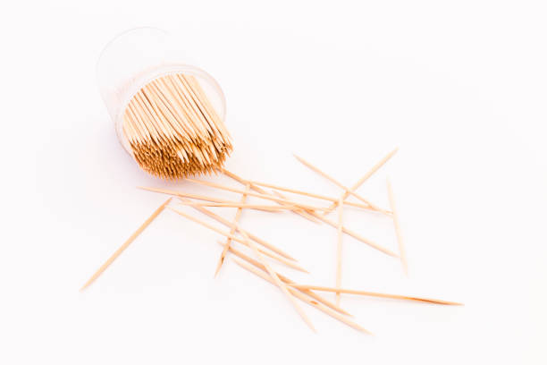 Wooden toothpicks in a transparent plastic container on white background