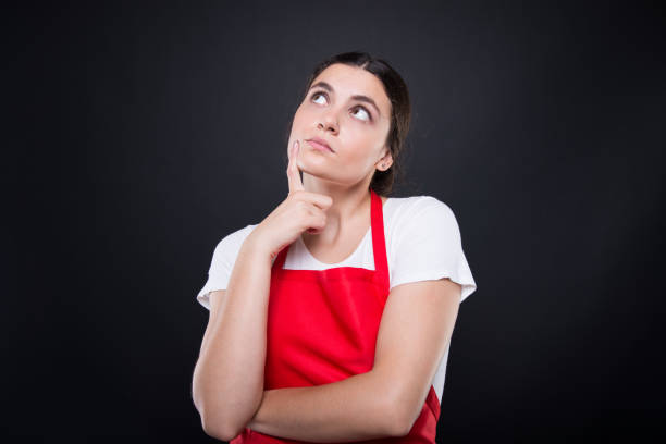 Beautiful seller girl with apron thinking stock photo