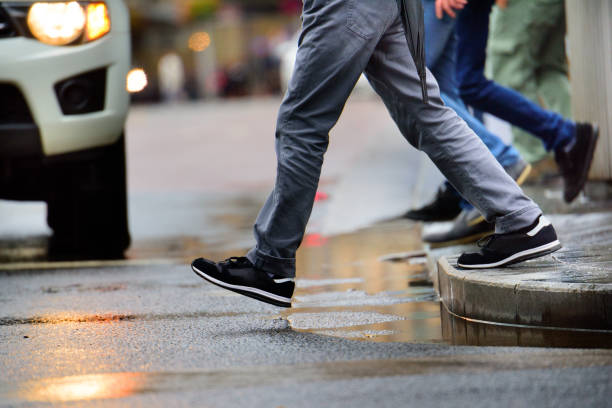 hombre pisando charco de lluvia - paso peatonal raya indicadora fotografías e imágenes de stock