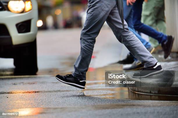 Man Stepping Over Puddle In Rain Stock Photo - Download Image Now - Pedestrian, Car, Australia