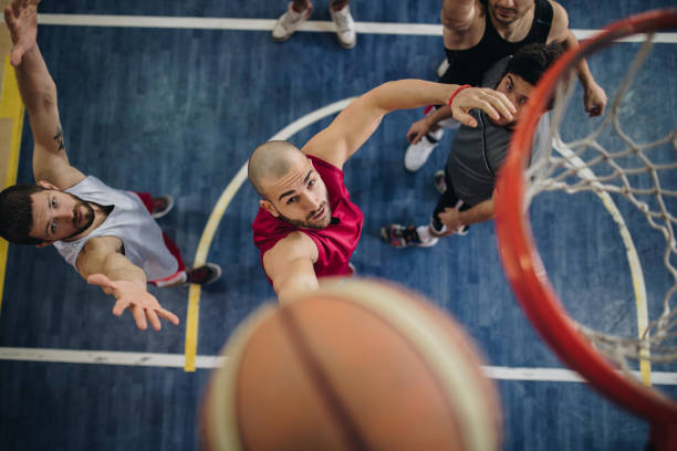 Above view of determined basketball players in action. High angle view of a basketball players playing a match on a court, while one of them is about to score. basketball player photos stock pictures, royalty-free photos & images