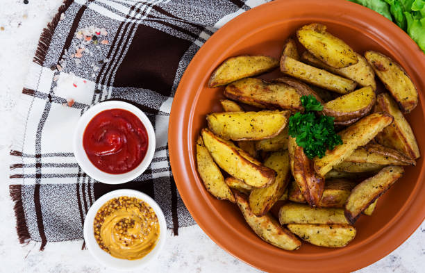istock Baked potato wedges with spices. Top view 861212416