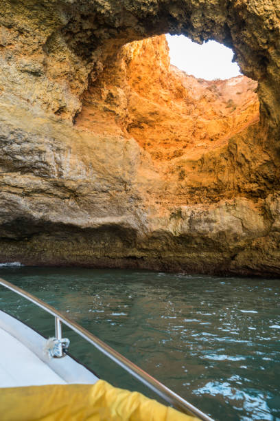 Scenic golden cliffs near Benagil, Lagoa, Algarve. View from a boat on the ocean Scenic golden cliffs near Benagil, Lagoa. This beach is a part of famous tourist region Algarve. View from a boat on the ocean. benagil photos stock pictures, royalty-free photos & images