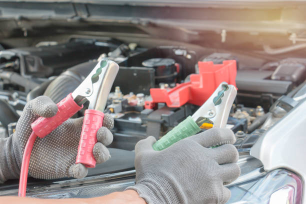 istock Car mechanic uses battery jumper cables charge a dead battery. 861220926