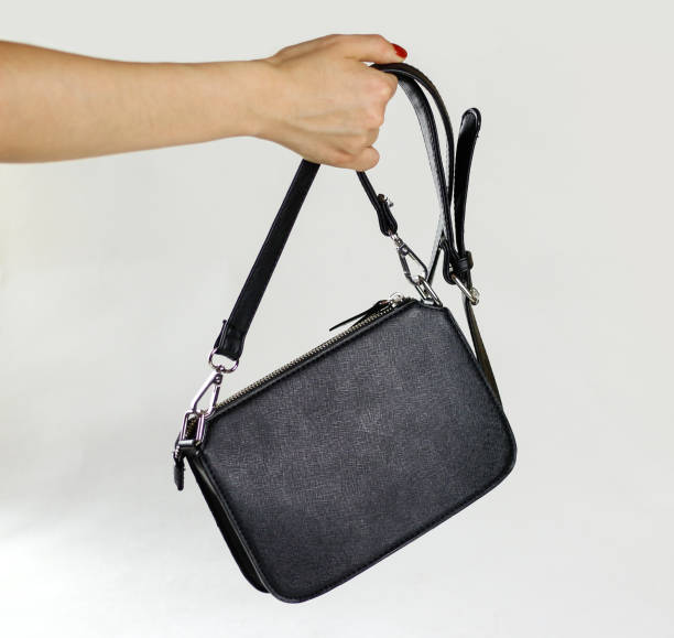 istock Female hand holding black purse. Closeup 861223884