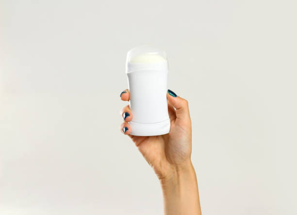 istock Female hands holding white deodorant. Isolated on gray background. Closeup 861226006