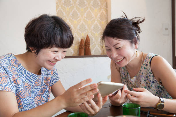 istock Japanese female friends looking at tablet together 861230714