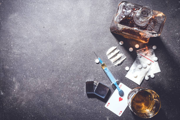 Hard drugs and alcohol on gray stone table stock photo