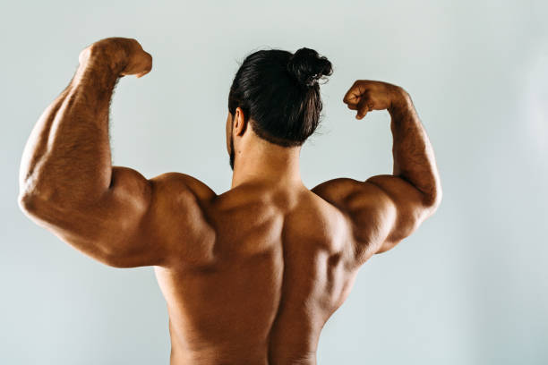 istock Male bodybuilder posing in studio, showing biceps on hands 861251794