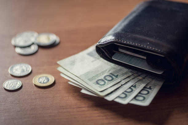 Walet with polich money Polsih PLN money, coins and notes, on the table near the lether walet. polish zloty stock pictures, royalty-free photos & images