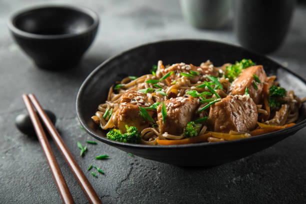 asian soba noodle and teriyaki salmon  in black bowl asian soba noodle and teriyaki salmon  in black bowl, selective focus chinese food photos stock pictures, royalty-free photos & images