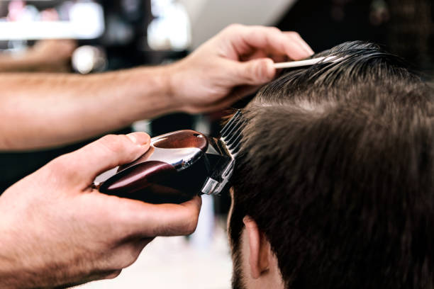 istock Barber with electric razor cutting hair 861255910