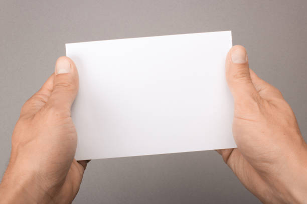 istock Blank postcard in hands on a gray background. Leaflet A6 mockup 861259570
