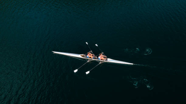 istock Two female athletes sculling on lake in sunshine 861260788