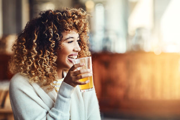 And now for something cold Shot of a young woman enjoying a drink at a bar woman drinking beer stock pictures, royalty-free photos & images