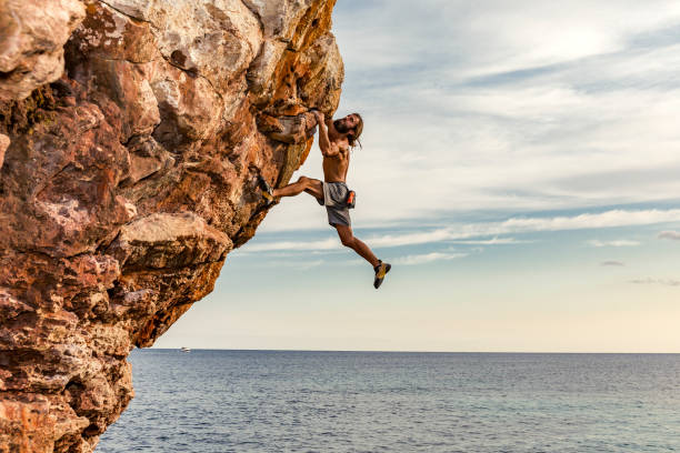 psicobloc rock climber at the sea - climbing men sea cliff imagens e fotografias de stock