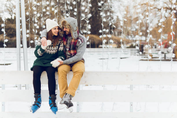 Young couple in love is enjoying winter day skating Young couple in love is enjoying winter day skating and flirting. Copy space. ice skating photos stock pictures, royalty-free photos & images