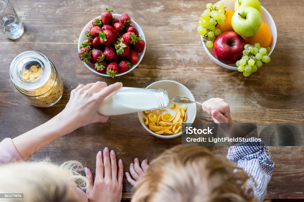 mother with child having breakfast overhead view of mother and son preparing corn flakes for breakfast Breakfast Stock Photo