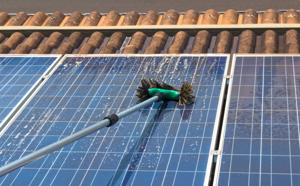 Cleaning solar panels on house roof stock photo