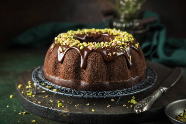 pastel chocolate con glaseado de chocolate y pistachos - chocolate bundt cake fotografías e imágenes de stock