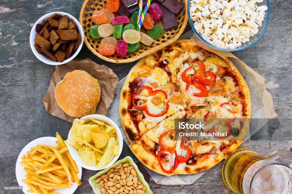 Fast food on old wooden background. Concept of junk eating. Top view. Unhealthy Eating Stock Photo