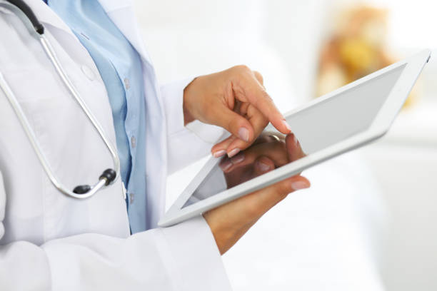 istock Woman doctor using tablet computer while standing straight in hospital 861280268