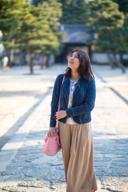 istock Young woman walking on stone walkway in temple 861287550