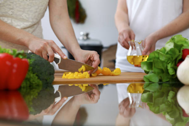 istock Close-up of  human hands  cooking in a kitchen. Friends having fun while preparing fresh salad. Vegetarian, healthy meal and friendship concept 861287792