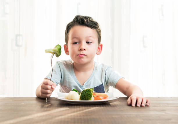 dziecko jest bardzo niezadowolone z konieczności jedzenia warzyw. - cute disgust carrot caucasian zdjęcia i obrazy z banku zdjęć