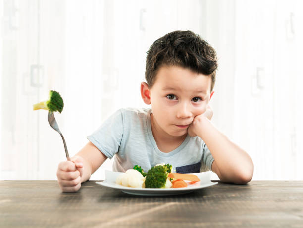 istock Child is very unhappy with having to eat vegetables. 861305598