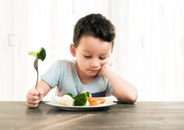istock Child is very unhappy with having to eat vegetables. 861305620