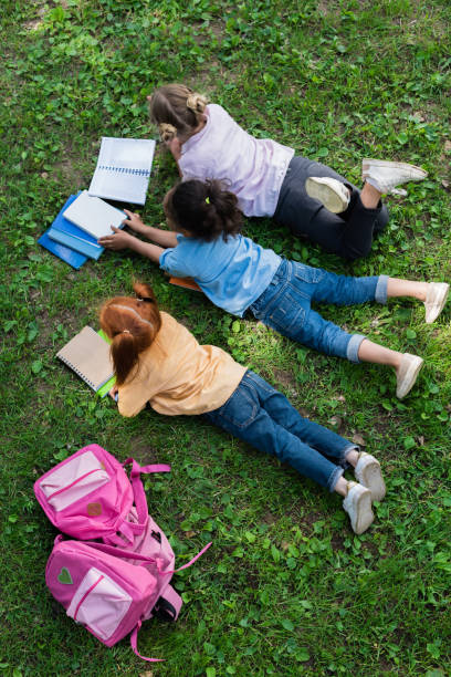 istock kids reading books in park 861306046