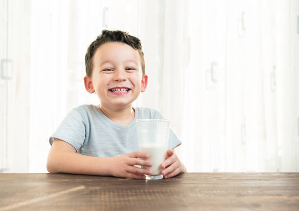 child drinking a glass of milk. - milk mustache imagens e fotografias de stock