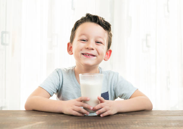 child drinking a glass of milk. - milk mustache imagens e fotografias de stock