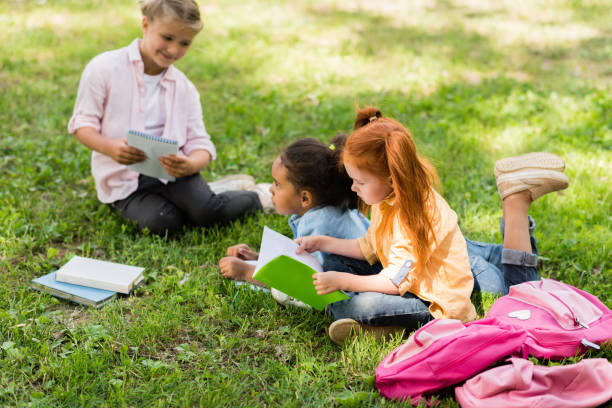 istock multiethnic schoolgirls studying on grass 861314210