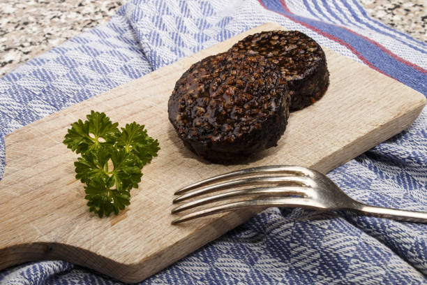 Cтоковое фото жареный ирландский черный пудинг из овсянки на д�еревянной доске с ножом