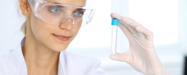 female scientific researcher in laboratory studying substances or blood sample. medicine and science concept - close up medical test exam people imagens e fotografias de stock