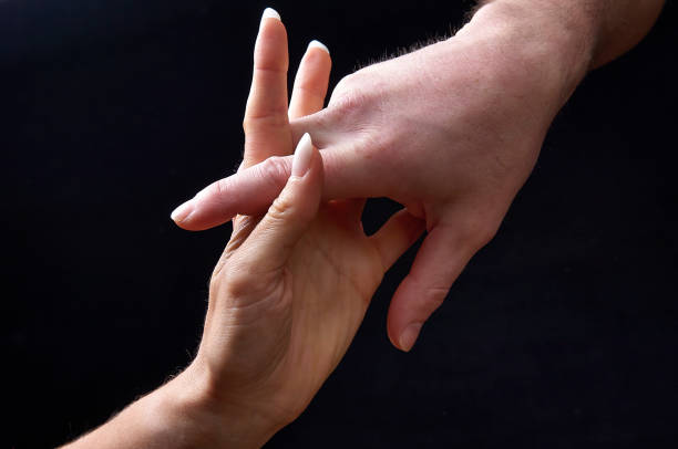 istock Male and female hands together on black 861333302