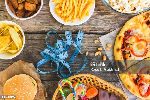 Fast Food Tape Measure On Old Wooden Background Concept Of Junk Eating Toned Image Top View Stock Photo - Download Image Now