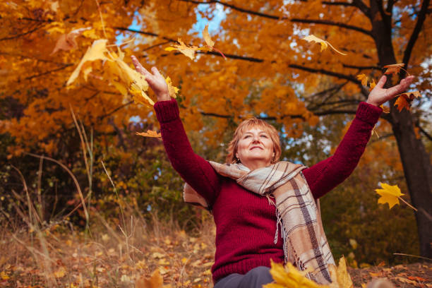 istock Middle-aged woman throwing leaves in the forest 861340584
